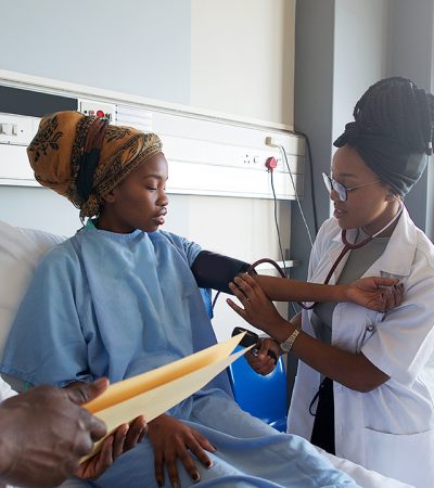 An African young Female Doctor taking blood pressure on a young patient with a headscarf Cape Town South Africa